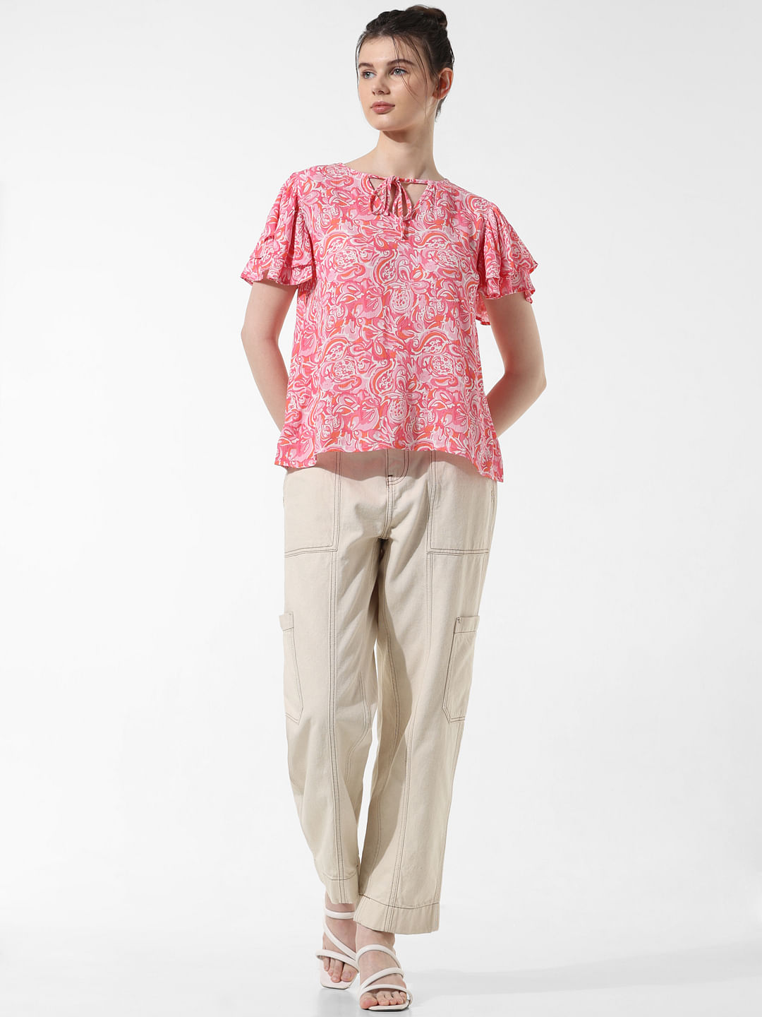 a woman wearing a pink shirt and black pants and white shoes Stock Photo by  Icons8