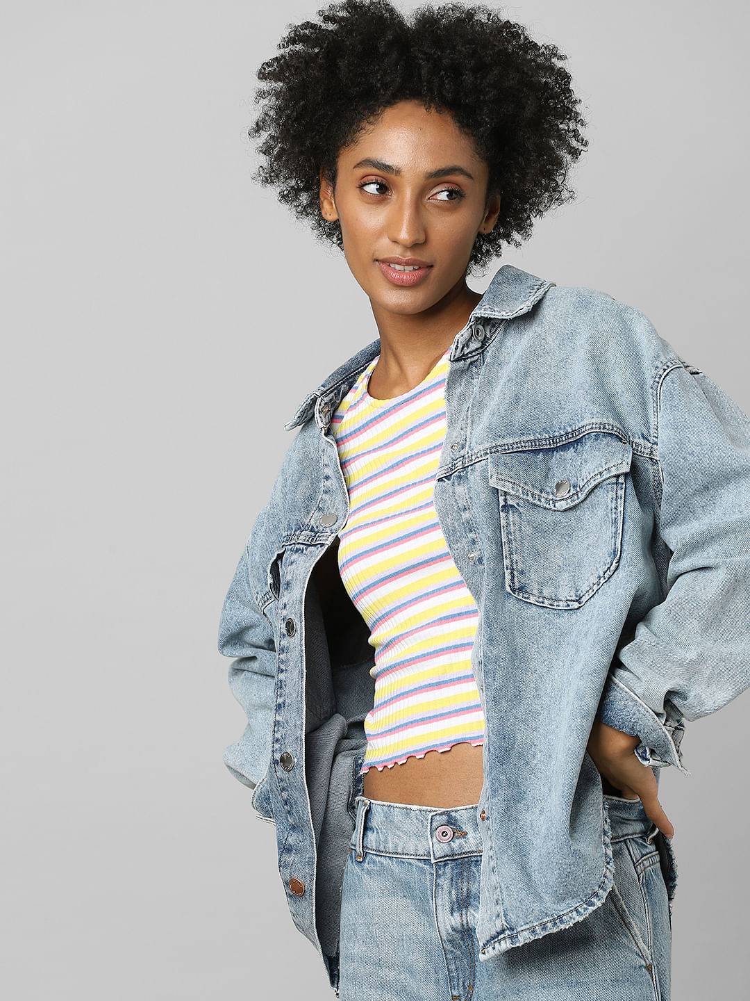 positive afro girl in denim jacket, yellow T-shirt and jeans chosing  clothes for party . selection concept Stock Photo - Alamy